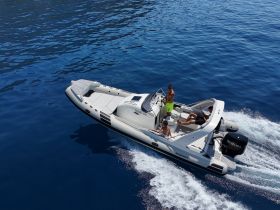A dynamic shot of a speedboat cruising through clear blue waters, showcasing a group enjoying their time on the water.