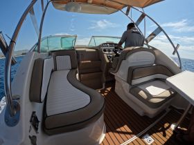 The interior of a boat featuring comfortable seating and a helm, showcasing a well-designed cabin space for navigation and relaxation on the water.