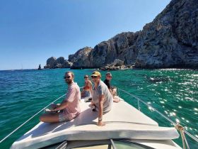 A cheerful group enjoys a sunny day on a boat, surrounded by stunning coastal scenery — perfect for memorable outings and adventures on the water.