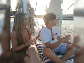 A couple enjoys cocktails on a yacht during sunset, creating a perfect romantic atmosphere for special occasions.