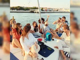 A lively group enjoys drinks and laughter aboard a yacht, capturing the essence of a perfect summer celebration on the water.