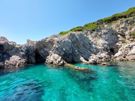 A stunning view of rocky coastline with crystal-clear turquoise waters, showcasing a perfect spot for exploration and relaxation.