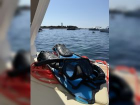A close-up of snorkel gear, including flippers and a mask, laid out on a boat, ready for an underwater adventure in clear waters.