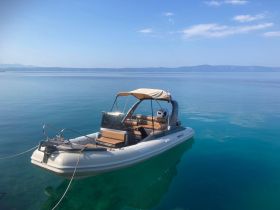 A sleek speedboat anchored in calm, clear waters, perfect for a day of exploration or relaxation on the sea.