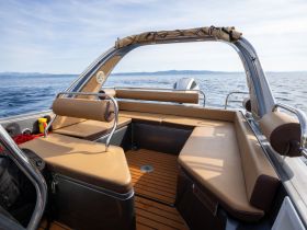 Interior view of a sleek boat cabin featuring comfortable seating and a well-designed helm area, perfect for enjoying a day on the water.