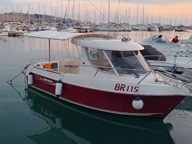A charming Arvor boat docked in a marina, showcasing its sleek design and tranquil surroundings — perfect for fishing or leisure outings.