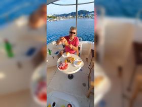 A man enjoys a delicious meal aboard a boat, showcasing fresh seafood and vibrant salads — perfect for a relaxing day on the water.