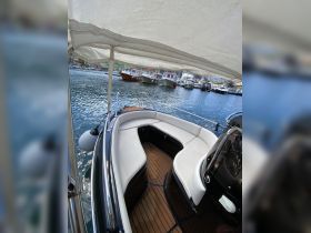 A cozy interior view of a boat featuring comfortable seating and a stylish helm, perfect for relaxing while cruising the waters.