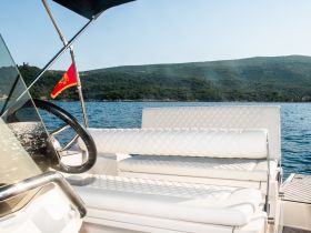 A stylish interior view of a boat's helm and seating area, showcasing modern design and comfort for an enjoyable boating experience.