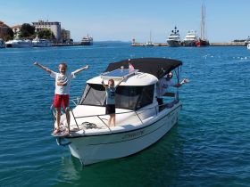 Two excited children and an adult enjoy a fun moment on a boat, showcasing the joy of family adventures on the water.