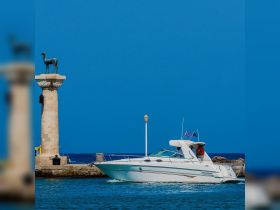 A sleek speedboat navigates the clear waters near a historic statue, showcasing the beauty of coastal adventures.