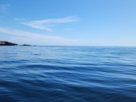 A view of calm waters under a clear blue sky, but the image lacks clarity and detail.