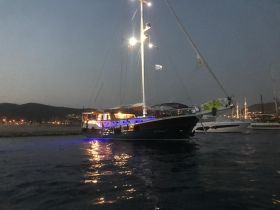 A beautifully illuminated yacht docked at night, showcasing its elegant design against a serene backdrop — perfect for evening cruises or private charters.