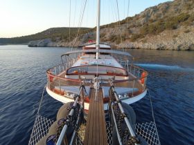 A stunning view of a yacht cruising through calm waters, showcasing its elegant design against a picturesque coastal backdrop.