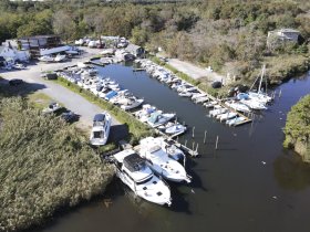Aerial view of a marina filled with various boats docked along the waterway, showcasing a vibrant boating community.