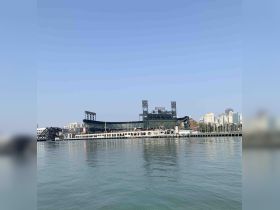 A view of a waterfront area featuring a stadium and city skyline, but the focus is unclear.