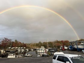 A stunning rainbow arcs over a marina filled with boats, creating a picturesque scene perfect for nature lovers and boating enthusiasts.