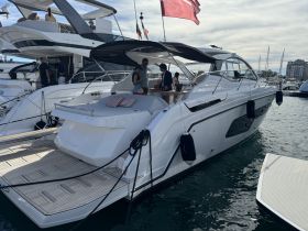 A stylish Azimut yacht is showcased at the dock, with guests engaging and enjoying the ambiance — perfect for luxury boating experiences.