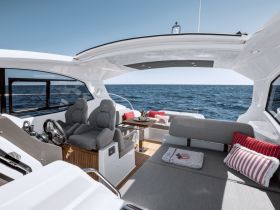 A stylish interior view of a yacht's helm and seating area, showcasing modern design and comfort for an enjoyable boating experience.