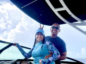 A joyful couple poses on the boat, showcasing their fun day on the water — perfect for capturing memorable moments during boating adventures.
