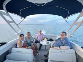A cheerful group of friends enjoys a relaxing moment aboard a Sea Ray boat, surrounded by calm waters — perfect for social gatherings and sunset cruises.