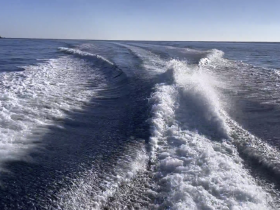 A view of the water's surface with wake trails, capturing the essence of boating but lacking clarity and focus.