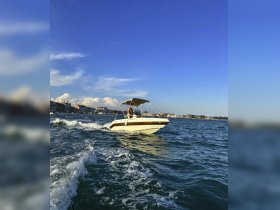 A speedboat navigates through the waves with a scenic city backdrop, capturing the essence of a thrilling day on the water.