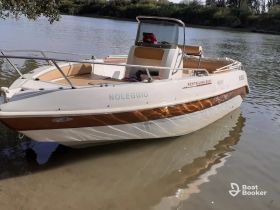 A sleek speedboat docked on calm waters, showcasing its elegant design and inviting seating area — perfect for a day of relaxation on the water.