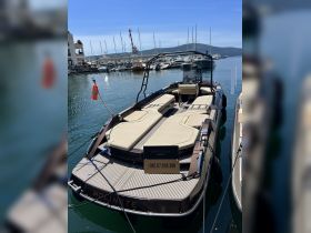 A sleek boat named 'MOLINETE' docked in a marina, showcasing its luxurious design and available for charter through Celestial Charter.