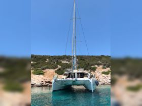A stunning catamaran docked in crystal-clear waters, surrounded by lush greenery — perfect for serene sailing adventures.