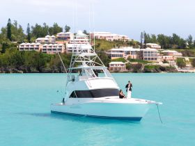 A couple enjoys the stunning turquoise waters of Bermuda aboard a luxurious yacht, showcasing the perfect blend of relaxation and adventure.