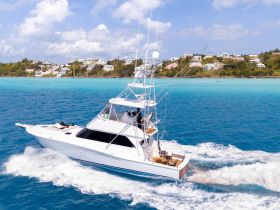 A stunning aerial view of a sleek yacht cruising through vibrant turquoise waters, showcasing the beauty of a perfect day on the water.