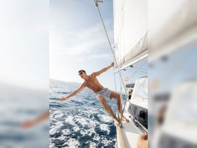 A man enjoys an exhilarating moment while sailing, showcasing the thrill of ocean adventures and the joy of being on the water.