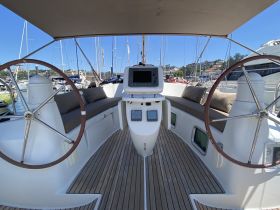 A well-appointed helm area inside a yacht, featuring comfortable seating and modern navigation equipment, perfect for a relaxing day on the water.