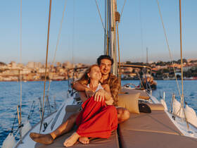 A couple enjoys a romantic moment aboard a yacht at sunset, capturing the essence of love and adventure on the water.