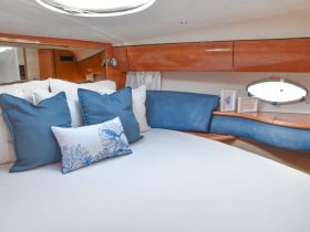 Cozy cabin interior featuring plush blue and white pillows, perfect for relaxation on a yacht.