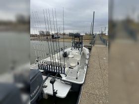 Interior view of a fishing boat equipped with multiple fishing rods and comfortable seating, perfect for a day on the water.