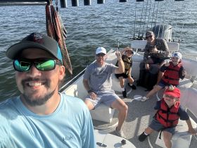 A joyful family enjoys a fishing trip on a boat, showcasing smiles and excitement as they create lasting memories together on the water.