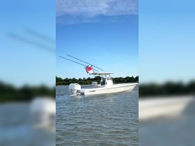 A sleek speedboat cruising through calm waters, showcasing its powerful design and fishing gear — perfect for adventurous outings on the water.