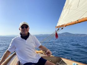 A man enjoys a relaxing day sailing on a beautiful ocean, capturing the essence of leisure and adventure on the water.