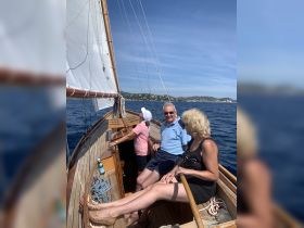 A group of friends enjoys a relaxing sailing experience on a beautiful day, surrounded by stunning coastal views — perfect for creating unforgettable memories on the water.