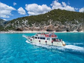 A lively boat cruise near a stunning beach, with guests enjoying the scenic views of the coastline and crystal-clear waters.