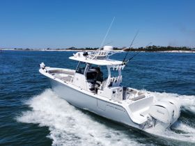 A sleek speedboat navigates through clear waters, showcasing its powerful design and performance. Perfect for thrilling day trips on the water.