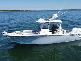 A sportsman boat navigates the water with a captain at the helm, perfect for fishing adventures and exploring coastal waters.