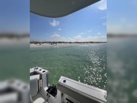 A scenic view from a boat showing a group enjoying a beach day on a sandbar, perfect for relaxation and fun in the sun.