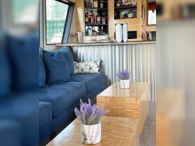 A stylish interior view of a boat's cabin featuring a cozy seating area and a well-stocked bar, perfect for entertaining guests on the water.