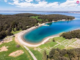 A stunning aerial view of a serene coastline and lush greenery, showcasing the natural beauty of the island — perfect for eco tours and scenic boat trips.