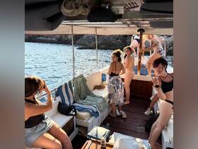 A lively group of friends enjoys their time on a boat, capturing fun moments and soaking up the sun — perfect for summer adventures on the water.
