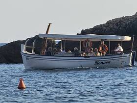 A lively group enjoys a boat ride on the water, surrounded by scenic rocky landscapes — perfect for exploring coastal destinations.