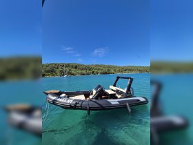 A sleek speedboat anchored in clear turquoise waters, surrounded by lush greenery — perfect for exploring coastal destinations.